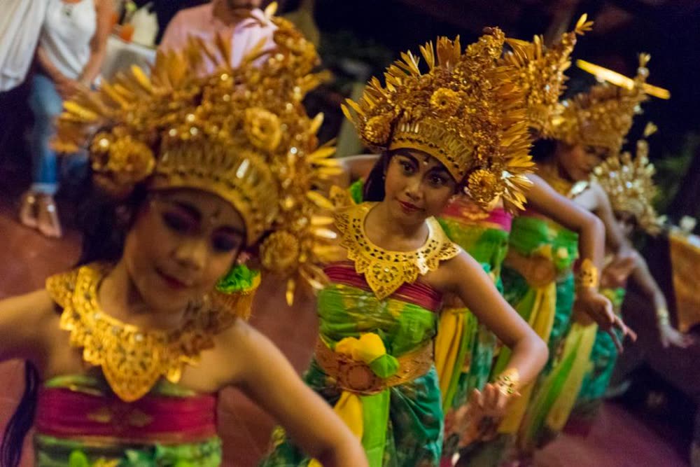 Young Balinese dancers in gold crowns performing a traditional dance at the retreat