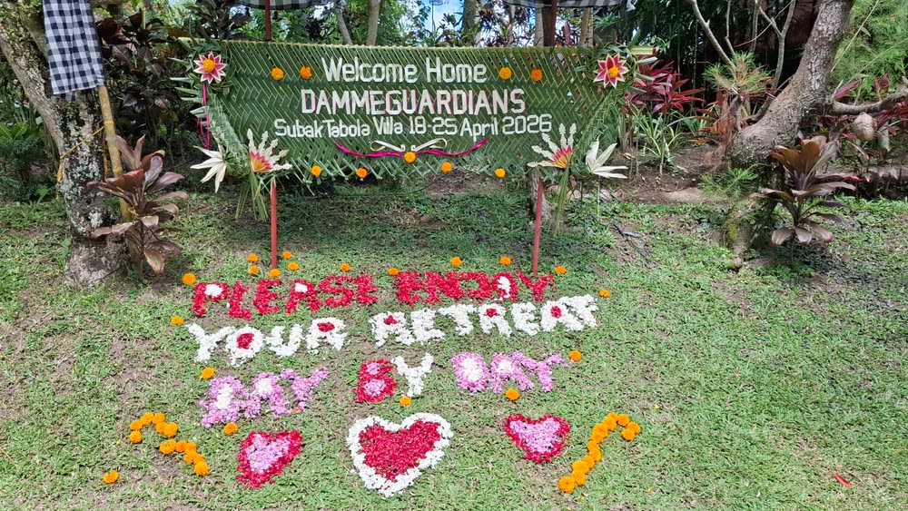 Woven palm sign reading Welcome Home Dammeguardians, with a greeting spelled out in flower petals